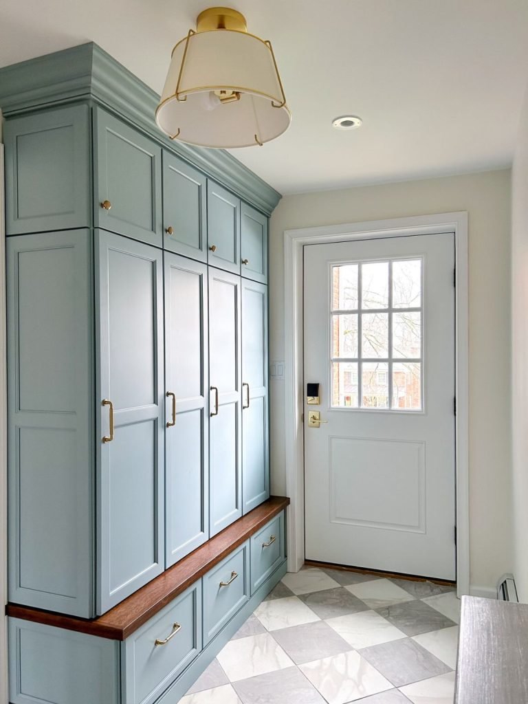 a mudroom with a white and gold mount light